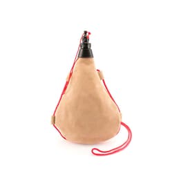 A drink bottle in a tan colour with a black spout and red straps for easy carrying. It features a simple logo.