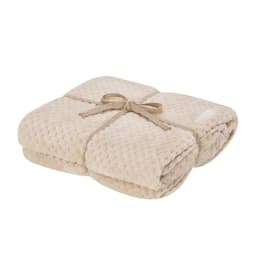 A folded cream-coloured Iridian Blanket tied with a jute ribbon, featuring a textured pattern.