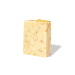 A bar of Gopax Soap in cream colour with embedded yellow floral pieces and a smooth surface, featuring a logo.