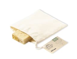 A solid soap bar in a natural fabric pouch, featuring a light beige colour with herbal inclusions.