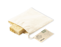 A solid bar of yellow soap in a reusable fabric pouch, featuring a tag with product information.