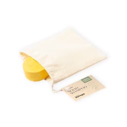 A yellow solid shampoo bar in a natural fabric pouch, accompanied by a product tag.