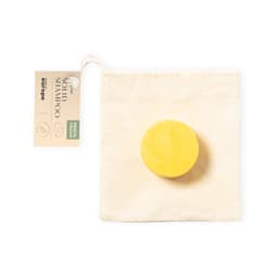 A yellow solid shampoo bar in a natural fabric pouch, featuring a logo and product label.