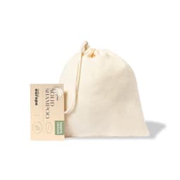 A cream-coloured pouch containing solid shampoo, featuring a tag that indicates it's 100% vegan.