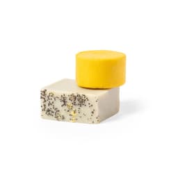 A yellow solid bar stacked on top of a white bar with black specks, showcasing a natural and raw appearance.