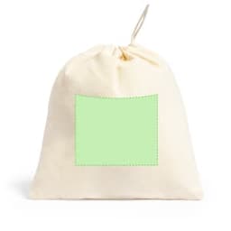 A drawstring bag in cream with a plain green patch for custom branding. It has a simple, versatile design.