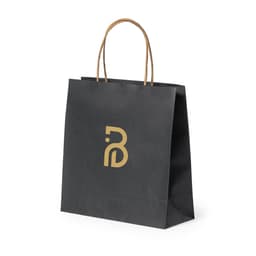 A black paper bag with brown handles and a branded logo in gold on the front.