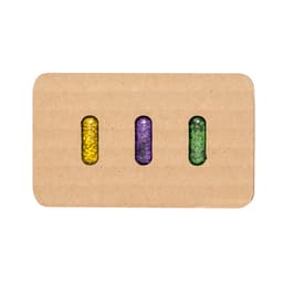 Three capsules filled with colourful seeds—yellow, purple, and green—packaged in a rectangular cardboard holder with branding.