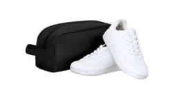 A black bag with a rounded shape alongside a pair of white sneakers. The bag features a handle.