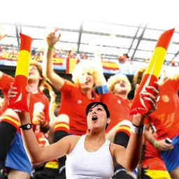 A woman in a white tank top holds two red and yellow inflatable sticks, cheering in a lively crowd at an event.