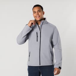 A light grey soft shell jacket is worn by a smiling person, featuring a small zippered pocket and a logo.