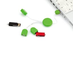 A green Pod USB drive with multiple connectors, alongside a black USB drive, placed next to a laptop.