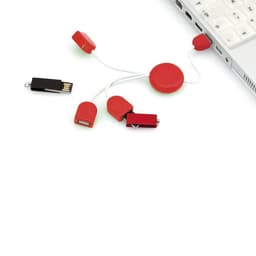 A red Pod USB drive with multiple connectors and a retractable cord, next to a laptop.