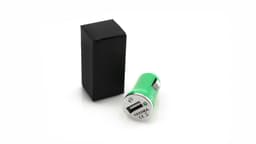 A green USB car charger beside a black box, featuring a silver connector and branding.