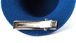 A blue hair clip with a silver clasp, featuring a soft fabric texture. The clip has a branding logo.