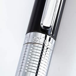 A sleek black and silver ballpoint pen featuring a polished chrome grip and a logo.