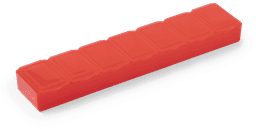 A red pillbox with seven compartments, designed for organising medications. It features a simple rectangular shape.
