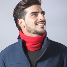 A man wearing a red scarf with a navy jacket, smiling against a light background. The scarf has branding.