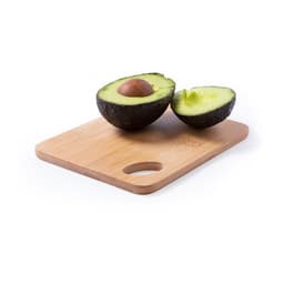 A wooden chopping board featuring a halved avocado, showcasing its vibrant green flesh and brown pit.