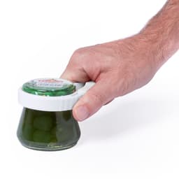 A hand holding a jar of green olives, featuring a white lid and a clear glass body.