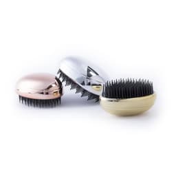 Three hairbrushes in metallic pink, silver, and gold with black bristles. Each brush has a sleek, rounded design.