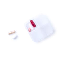 A pill organiser with compartments contains a red capsule, a pink tablet, and a white capsule.