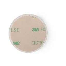 A circular adhesive pad with a smooth surface and a 3M branding on one side. Features a light colour tone.