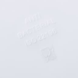 A white surface features embossed text indicating antibacterial properties and symbols of a cup and fork.