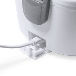 A white electric lunch box with a grey handle, featuring a cable connection at the base.