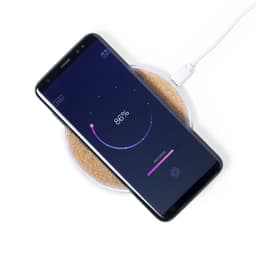 A wireless charger in a round shape with a smartphone displaying a charging progress bar. The charger has a light-coloured base.