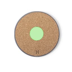 A round wireless charger with a cork surface and a green circular indicator in the centre. It has a minimalist design.