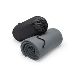 A grey blanket neatly rolled and compacted in a black carrying pouch, featuring a drawstring closure.