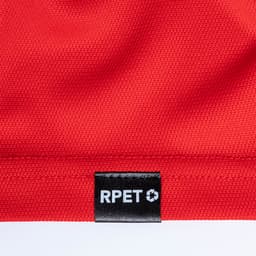 A red polo shirt featuring a textured fabric and a small logo tag.