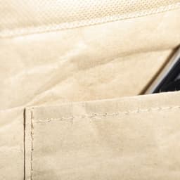 A beige cooler bag with a visible pocket and a drink bottle or phone partially inserted. Features stitching details.