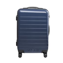 A navy wheeled bag with a sleek, ribbed design and a logo, featuring a sturdy handle and four wheels.