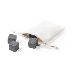 A drawstring pouch containing four dark grey square stone ice cubes, resting on a white background.