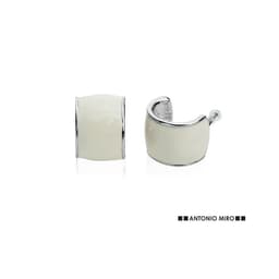 A pair of silver and white earrings with a smooth, curved design and a logo.