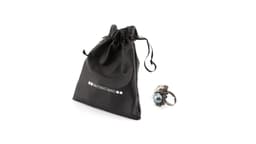 An adjustable ring with a cluster of pearls in grey, white, and blue beside a black drawstring pouch.