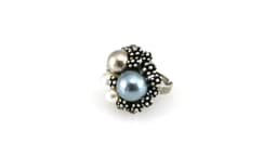 A silver adjustable ring featuring three large decorative pearls in shades of blue, grey, and white.