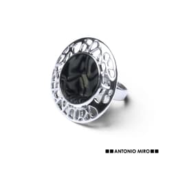 A silver adjustable ring featuring a textured black stone in a circular setting and a decorative cut-out design.