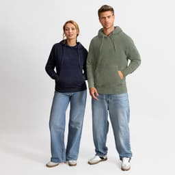 A navy and olive green hoodie worn by a woman and a man, featuring a front pocket and hood. Both model relaxed denim jeans.