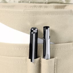 A cream-coloured bag with two pens positioned in a front pocket, displaying a simplistic design.