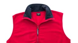 A red polar fleece jacket with a navy collar and a zippered front. It features a logo on the tag.