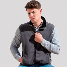 A man wearing a grey polar fleece jacket with a zip, featuring a black collar and logo.