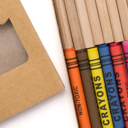 A gift set featuring coloured pencils in vibrant shades, including pink, blue, yellow, and orange, in a cardboard box.