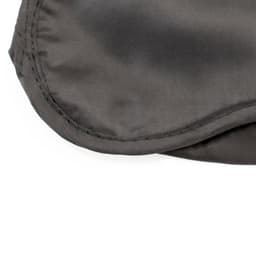 A soft, grey travel eye mask with a smooth texture and stitched edges. It features a logo.