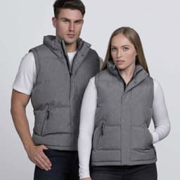 A grey puffer vest is worn by a man and a woman, both posing against a plain background. The vest has a logo.