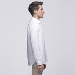 A side profile of a man wearing a white linen button-up shirt. The shirt has a collar and features a logo.