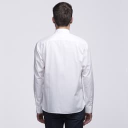 A white button-up shirt viewed from the back, featuring a collar and long sleeves. It has a logo on the back.