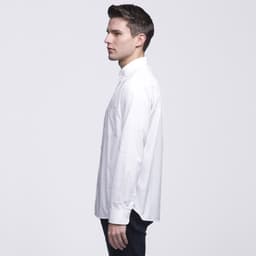 A man wearing a white button-up shirt, viewed from the side, with a simple design and a logo on the fabric.